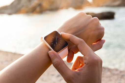 Istanbul, Turkey - August 2, 2015: Istanbul, Turkey - August 2, 2015: A woman wearing 42mm stainless steel Apple Watch with white sports band. The Apple Watch became available April 24, 2015, bringing a new way to receive information at a glance, using apps designed specifically for the wrist.