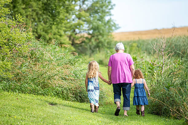 zwei junge mädchen & oma dort gehen sie auf der farm - green shoe blue in a row stock-fotos und bilder