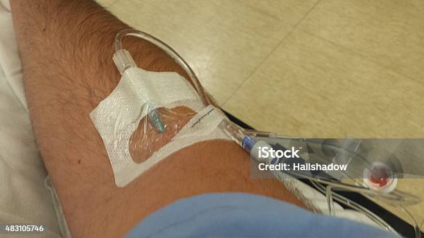 Patient Arm With Intravenous Drip Inserted In Arm Stock Photo - Download Image Now - 2015, Accidents and Disasters, Bed - Furniture