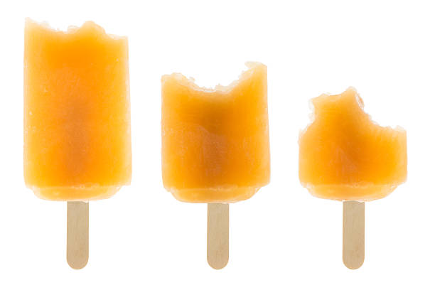 top view yellow popsicle in a melting process on pink background