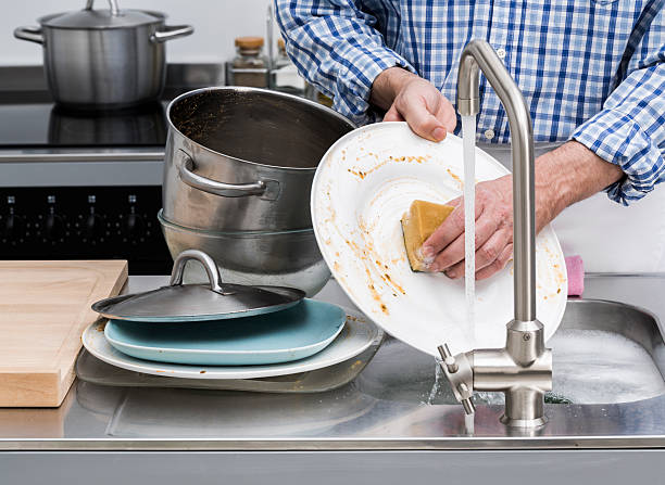 Washing dishes Man washing dishes in kitchen sink wash dishes stock pictures, royalty-free photos & images