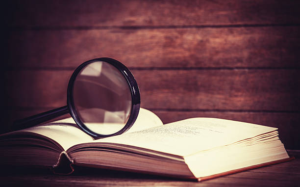 istock Loupa and book on wooden table 483117191