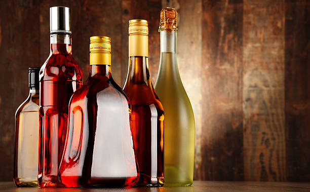 four bottles with vinegar made from quince,honey,mango and raspberry