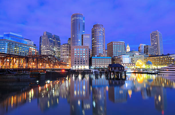 Boston Harbor Financial District of Boston, Massachusetts viewed from Boston Harbor. boston skyline night skyscraper stock pictures, royalty-free photos & images