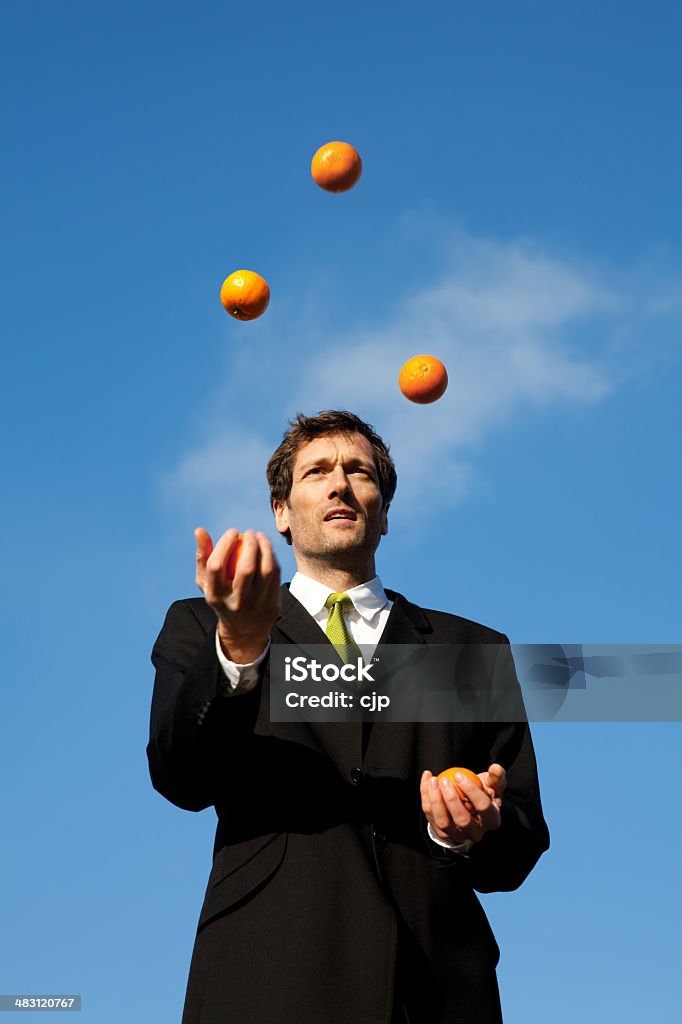 Imprenditore Fare il giocoliere arance esterno - Foto stock royalty-free di Fare il giocoliere