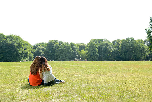 istock Girlfriends sitting on meadow in park 483123682