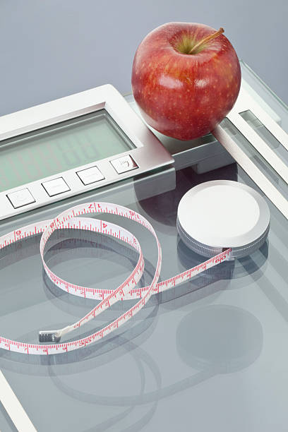 istock Apple and measuring tape on scales 483127768