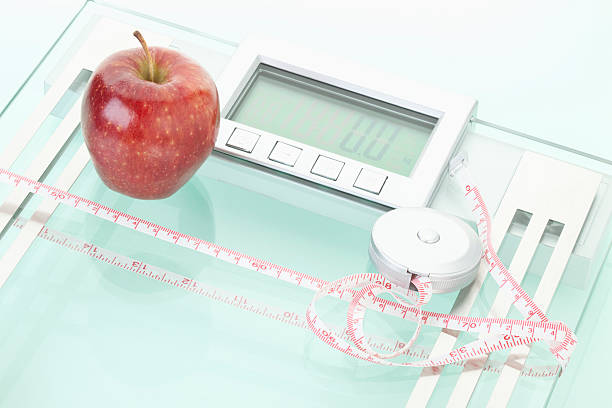 istock Apple and measuring tape on scales 483127778