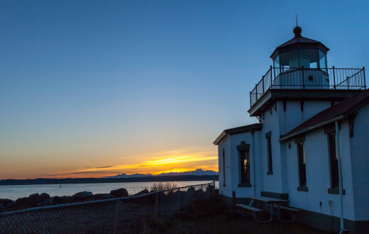 This image shows the West Point Lighthouse at Discovery Park in Seattle, WA at sunset.