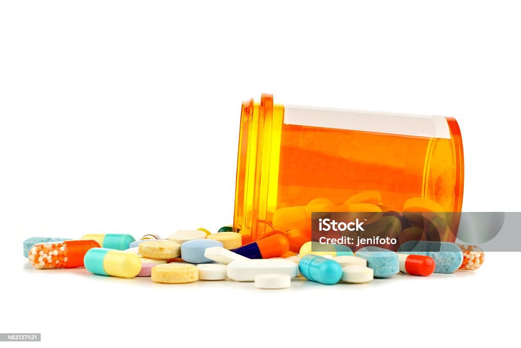 Pill bottle with spilling varied medicine over white Prescription Medicine Stock Photo