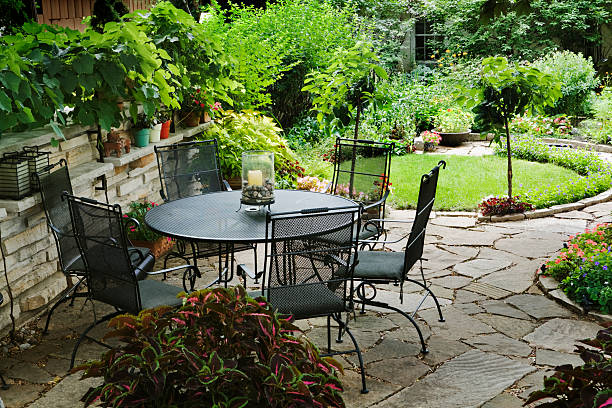 patio-mobiliar im garten mit blumenbeeten gestalteten ziergarten - flower bed formal garden ornamental garden furniture stock-fotos und bilder