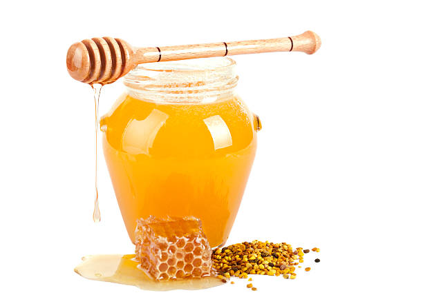Jar of honey with wooden drizzler Jar of honey with wooden drizzler pollination photos stock pictures, royalty-free photos & images