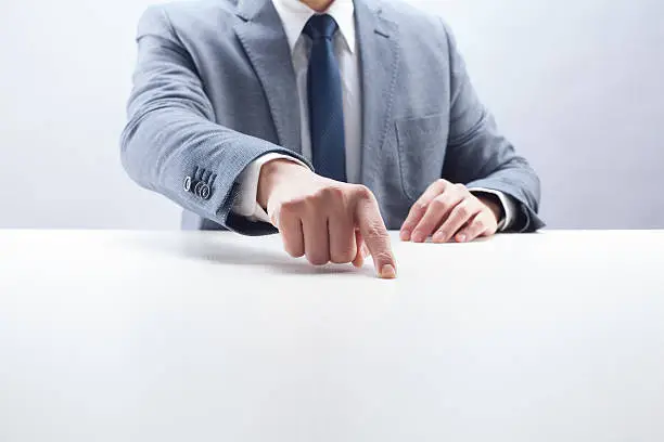 Businessman pointing on empty desk.