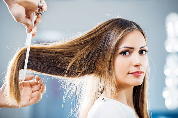 At the hairdresser's. Young woman at the hairdresser's looking at the camera. human hair women brushing beauty stock pictures, royalty-free photos & images