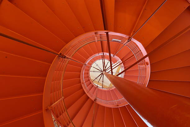 istock Orange round staircase in modern office building 483147151