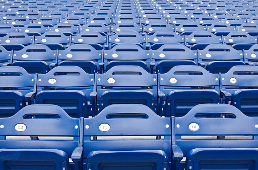 Rows of empty blue stadium seating in sporting arena