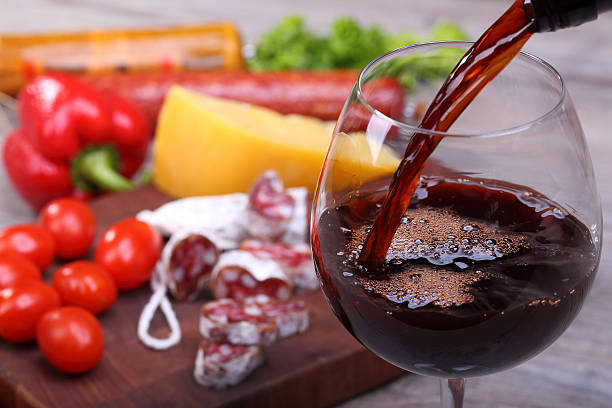 istock Pouring red wine and food background 483148585