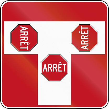 Regulatory road sign in Quebec, Canada - T intersection with stop signs and priority to right. Arret means stop.