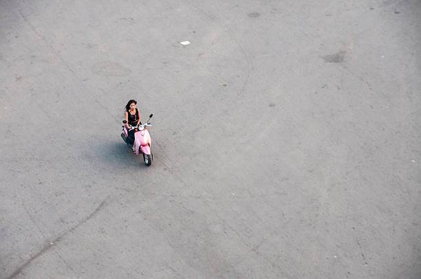 Gijón, Spain- May 11, 2018: Side view of beautiful old fashioned pink vespa scooter stationary on sidewalk. Old stone facade in the back ground, copy space on the right. Gijón, Asturias, Spain.