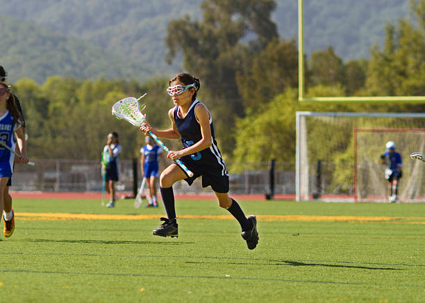 menina jogando lacrosse meados ar - óculos de proteção imagens e fotografias de stock