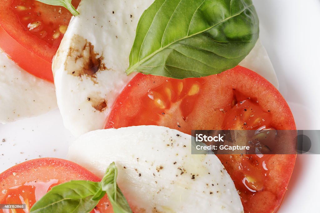 caprese salad made on cutting board caprese salad with balsamic made on white plate Balsamic Vinegar Stock Photo