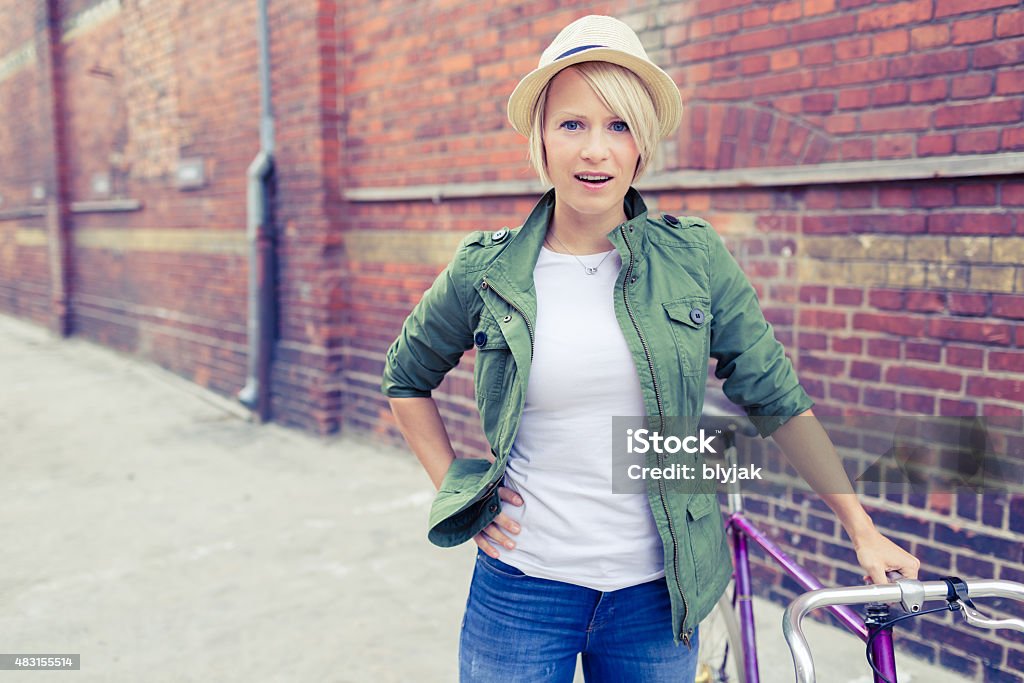 Hipster woman with vintage road bike in city Hipster cyclist young beautiful girl with vintage road bike on city street, urban scene. Commuting to work concept. Woman cycling on fixed gear bike in town, retro city street industrial background. 2015 Stock Photo