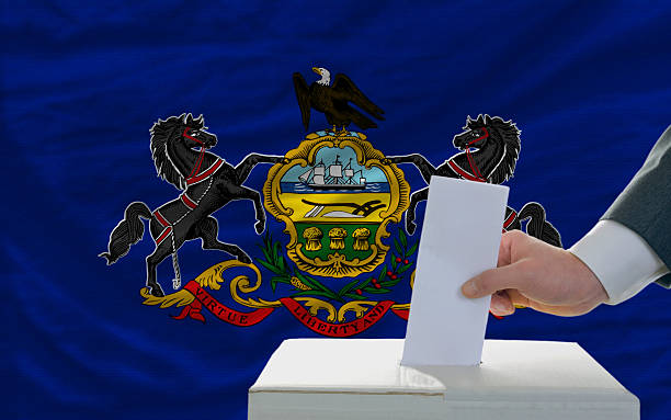 istock man voting on elections in front  flag of pennsylvania 483166435