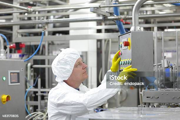 Technician At Control Panel In Lab Pressing Buttons Stock Photo - Download Image Now