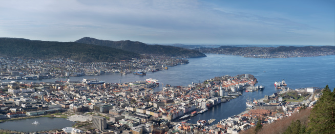 Bergen, Norway - April 4, 2014: Panoramic view of the Harbour area and City Center of Bergen (on the West Coast of Norway) on a sunny midday in april - viewed from the mountain Floien (or Floyen) - one of seven mountains surrounding the city. The image is a composite of 8 stitched images shot vertically.