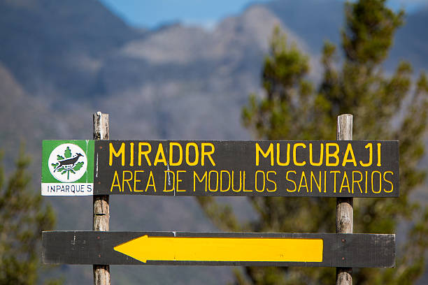 Directional sign to the Mirador Mucubaji in Merida, Venezuela Merida, Venezuela - April 30, 2015: Wooden road sign showing the direction toward the Mirador Mucubaji with the forest and mountains in the background. Venezuela 2015. landscape of the mountains in merida venezuela stock pictures, royalty-free photos & images