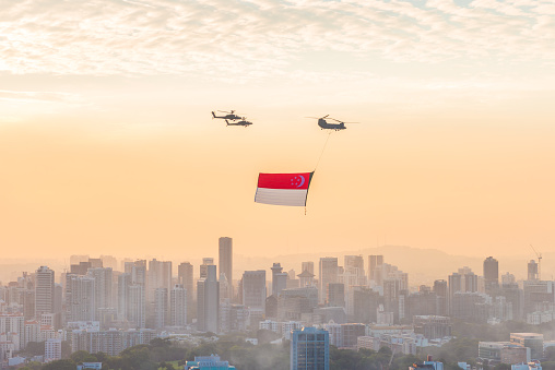 Singapore, Singapore - August 1, 2015: Singapore 50years National Day rehearsal helicopter hanging Singapore flag flying over the city