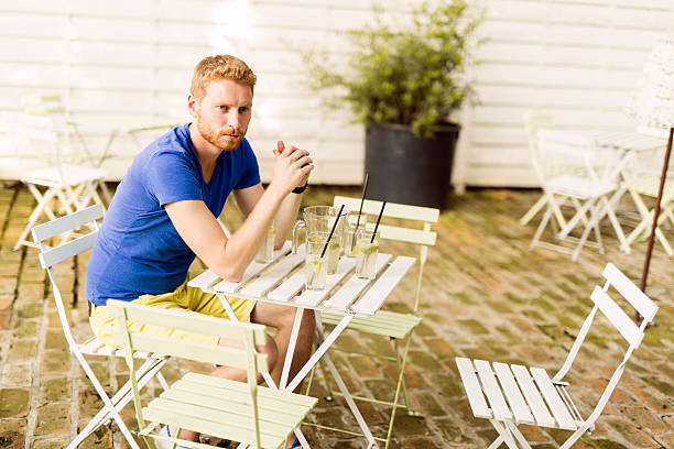 istock Thoughtful ginger male waiting at a table outdoors 483178854