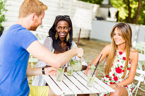 istock Young and happy friends sitting talking at a table 483179712