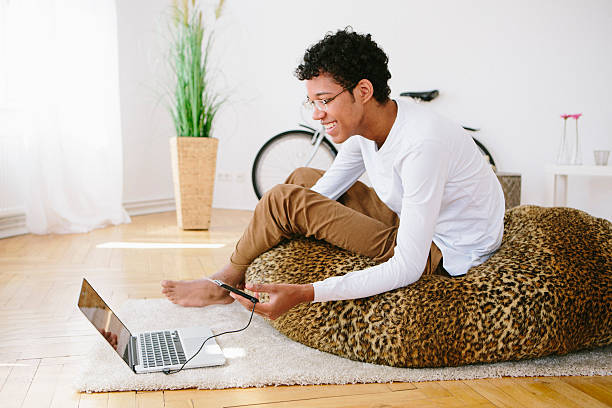 istock young laughing african man looks in his laptop, card reader 483183596
