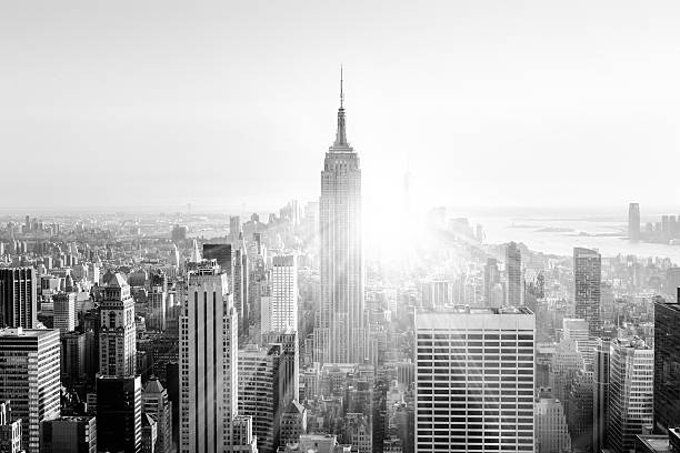 New York City Manhattan skyline in sunset. New York City. Manhattan downtown skyline with illuminated Empire State Building and skyscrapers at sunset. Vertical composition. Sunbeams and lens flare. Black and white image. skyscraper photos stock pictures, royalty-free photos & images