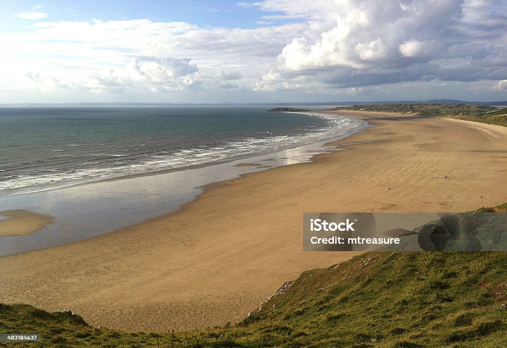 Beachfront and coastline of Rhossili Bay Photo showing the expansive beach of Rhossili Bay, located on the Gower Peninsula in South Wales.  This beautiful natural beachfront has recently been voted as 'Britain's Best Beach'. Swansea Stock Photo