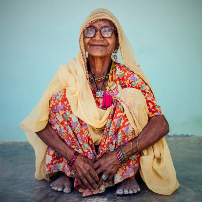 Smiling indian woman in colorful traditional clothes sitting. Real People Portrait. Rajasthan, India.