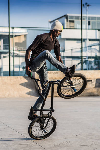 Kazan, Russia - August 17, 2021: The cyclist rides in an extreme park. The stuntman close-up. The skate park, rollerdrome, quarter and half pipe ramps. Extreme sport, youth urban culture.