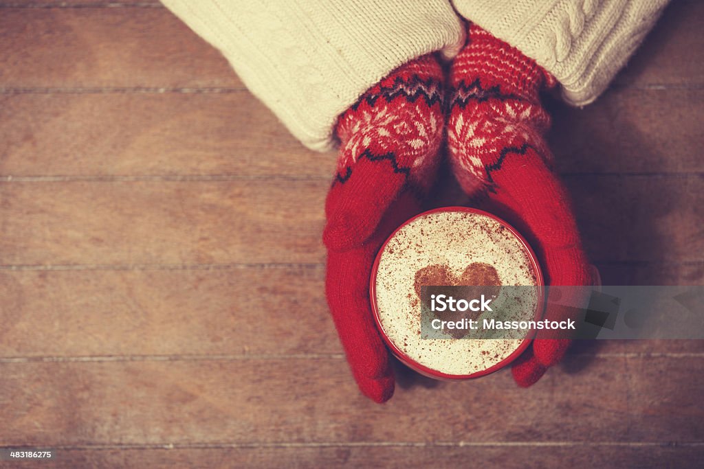 Hands in mittens holding hot cup of coffee Hands in mittens holding hot cup of coffee. Photo in old color imagestyle. Adult Stock Photo