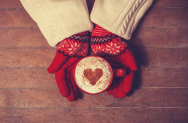 istock Hands in mittens holding hot cup of coffee 483186357