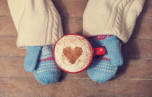 istock Hands in mittens holding hot cup of coffee 483186441