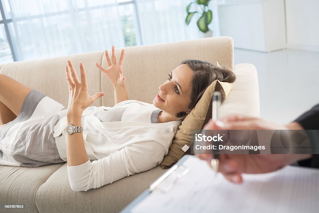 Emotional discussion Image of female patient talking about her problems with emotions at therapy session on the foreground Lying Down Stock Photo