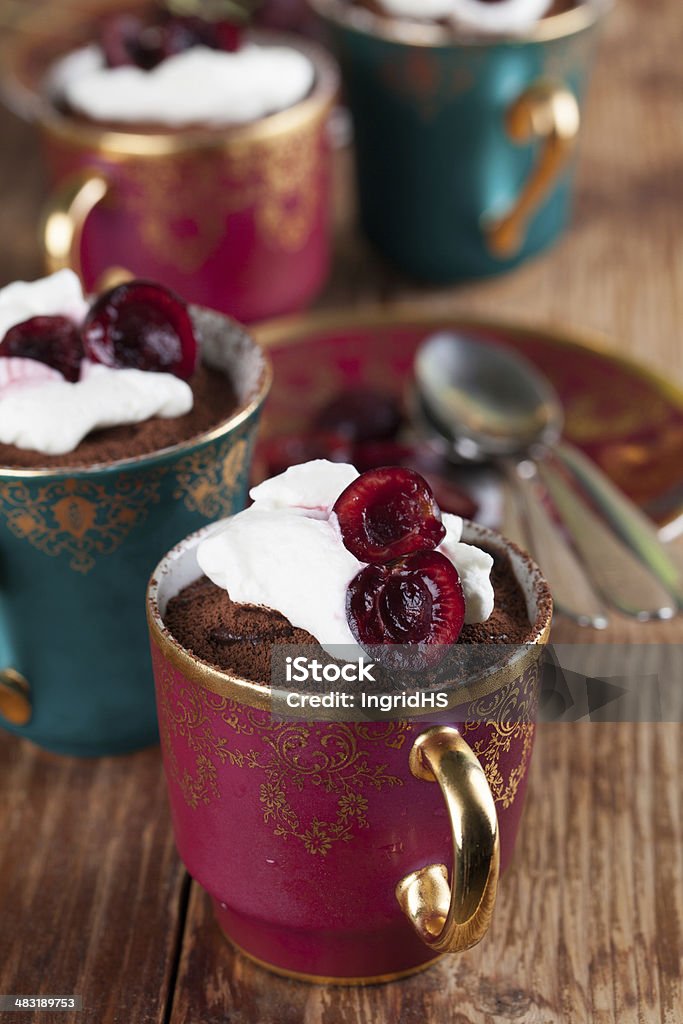 Raw vegan avocado chocolate mousse with cherries Raw vegan avocado chocolate mousse with cherries and coconut whipped cream.  Avocado Stock Photo