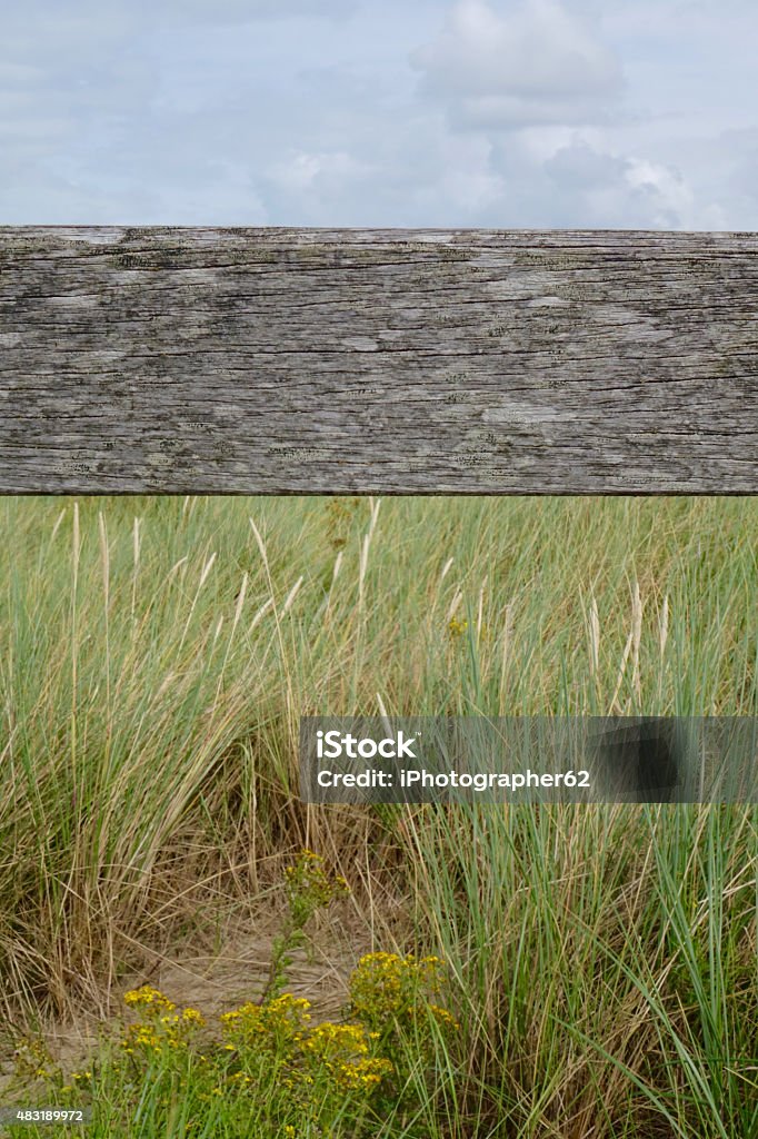 old wooden beam with grass and sky old and a little bit morbid wooden beam nearby with grass and sky 2015 Stock Photo