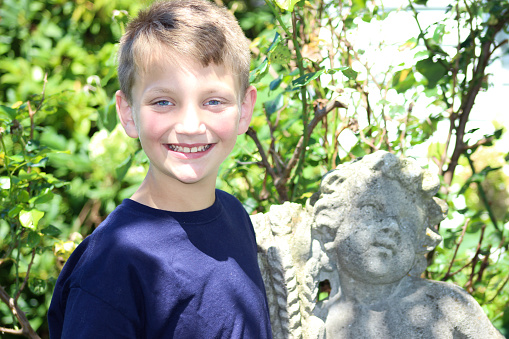 Young Boy Poses by Stone Statue