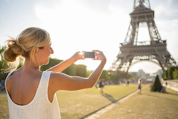 Photo of Young cheerful woman at Eiffel tower-Paris, France taking a selfie