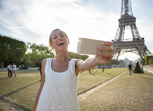 Photo of Attractive woman taking selfie at the Eiffel tower-Paris