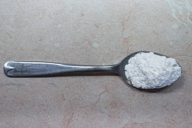 Overhead View of Teaspoon of Measured Baking Powder/Soda/Flour A heaped teaspoon of baking powder, to be used as a leavener in baking, such as baking cakes. teaspoon stock pictures, royalty-free photos & images