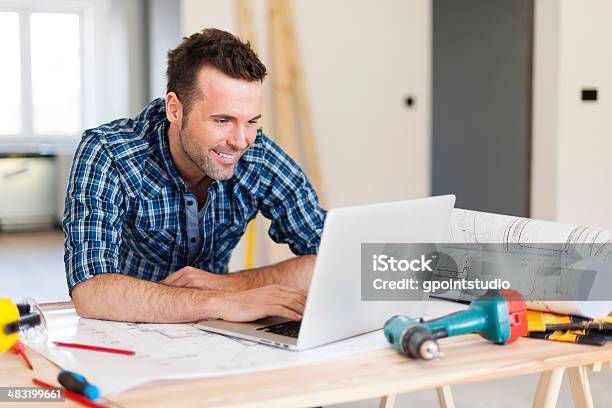 Smiling Construction Worker Working With Laptop Stock Photo - Download Image Now - Building Contractor, Laptop, Construction Worker