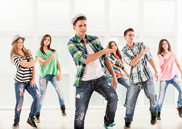 Teenage dancers. Group of teenage dancers exercising. Focus is on foreground.   dance troupe stock pictures, royalty-free photos & images